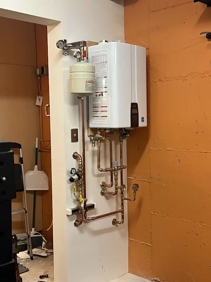 Plumbing technician inspecting water heater connections in Lake Stickney